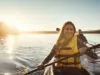 A young couple kayaking on a lake.